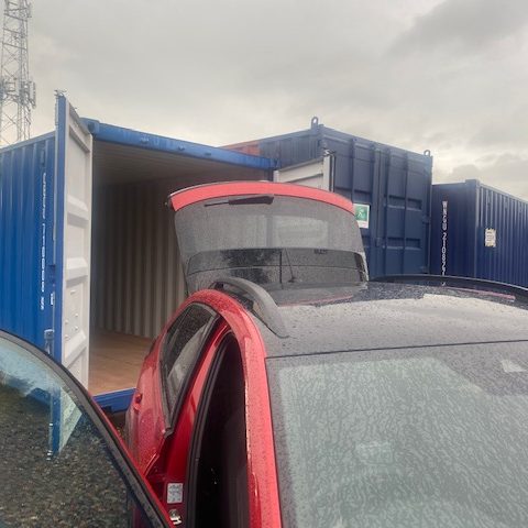 car delivering next to storage units