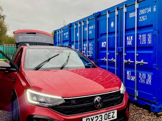a car unloading items into a shipping container