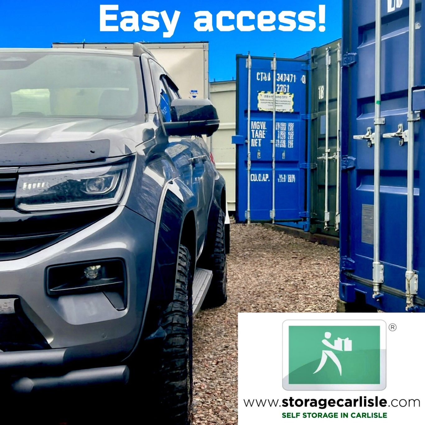 A grey vehicle parked next to blue storage containers with a sign reading "Easy access!"