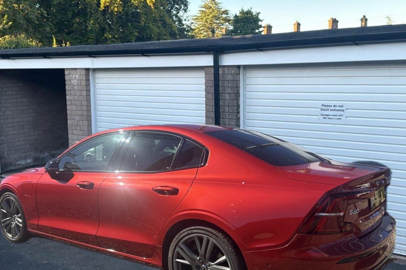 a motor car parked outside a lock up garage