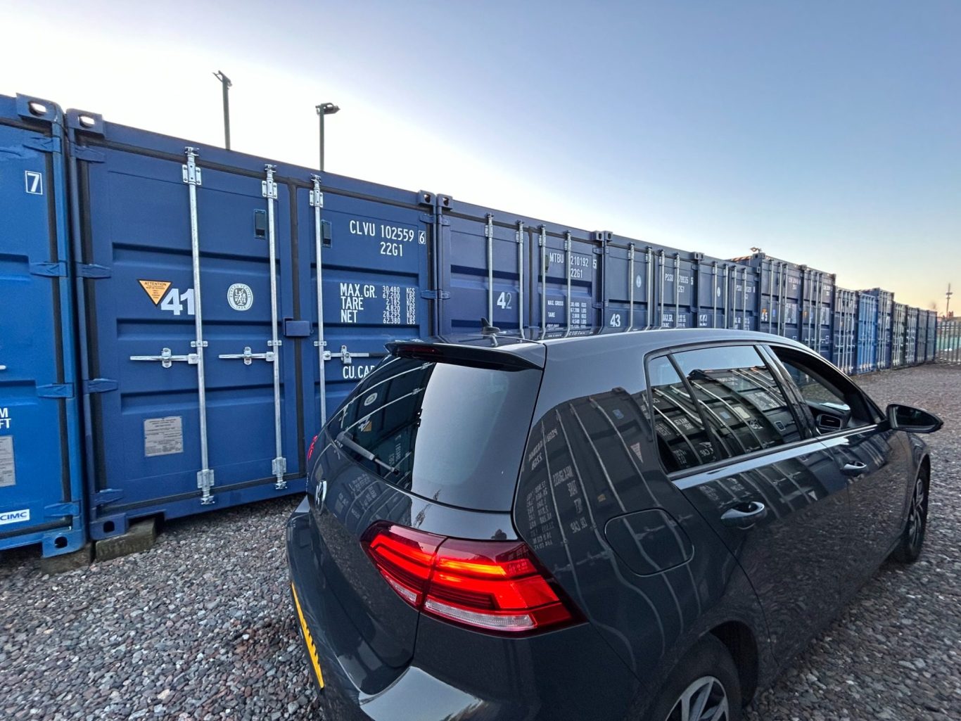 a motor vehicle parking next to a self storage unit