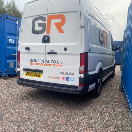 a delivery van next to a shipping container