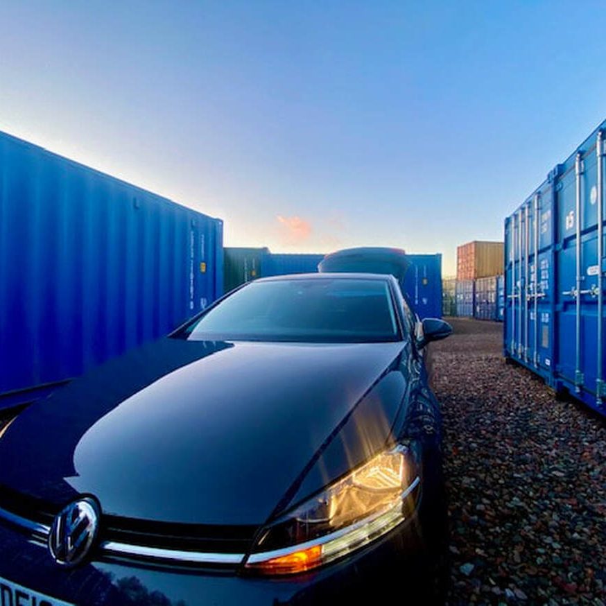 a car parked next to a shipping container