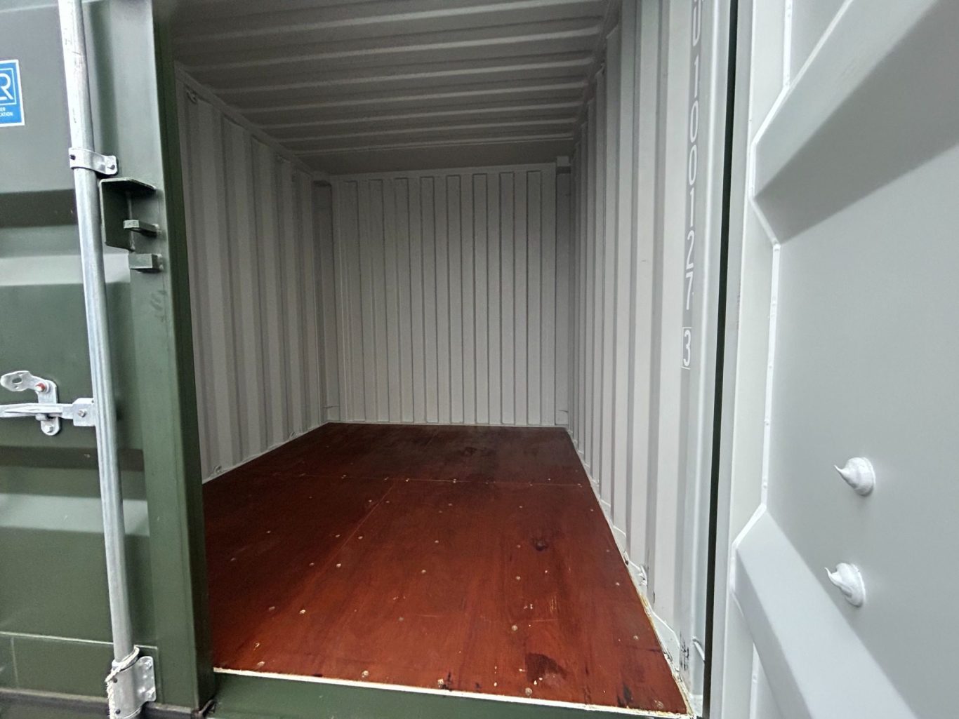 Empty shipping container interior with wooden flooring.