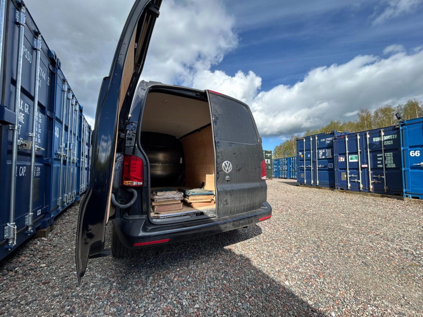 a medium size van unloading documents and books into a storage container unit