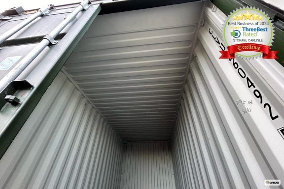 Empty shipping container interior viewed from the entrance, showcasing metal walls and ceiling.